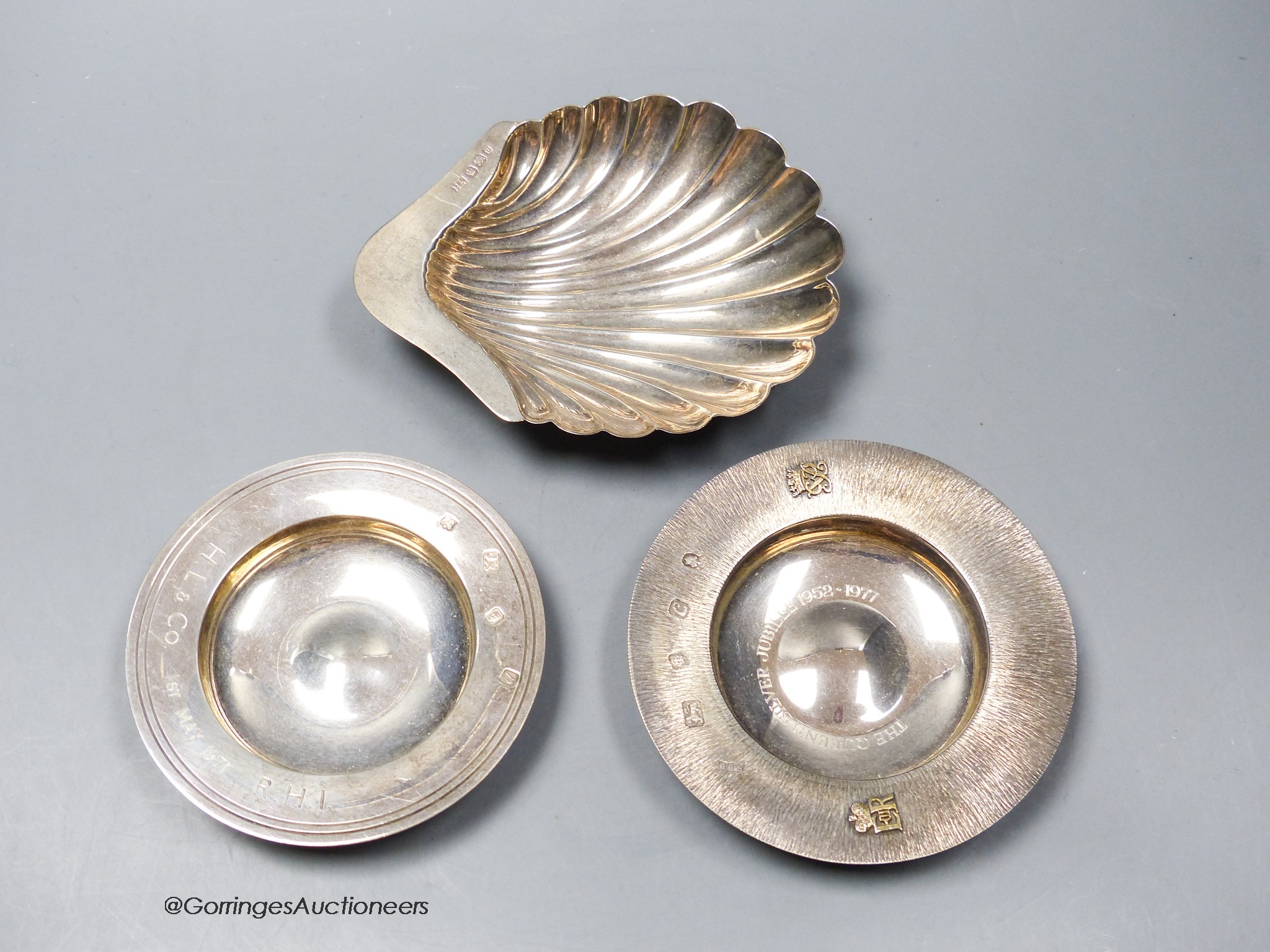 Two small silver commemorative dishes and a silver butter shell, 12.1cm, 5.5oz.